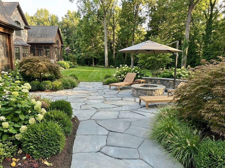 Irregular flagstone with layered plantings — boxwood, hydrangea, ornamental grasses.